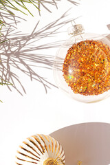 Christmas or New Year concept minimalism greeting card with a festive ball with sparkles inside on the white bright background. Top view. 