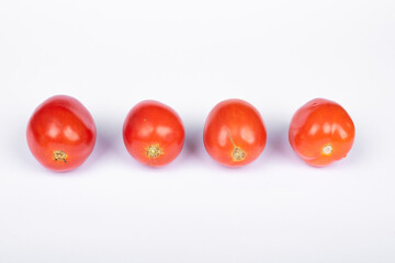 four tomato in a row on white background