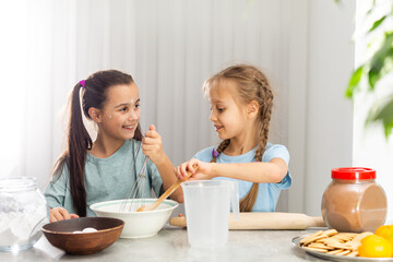 two little girls prepare Christmas cookies in the kitchen