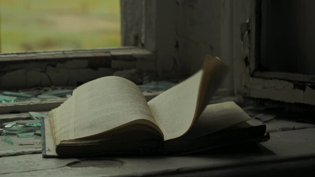 The pages of a textbook flutter on a broken windowsill in an abandoned school in the village of Teriberka, Russia.