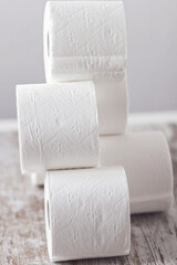 A pile of soft paper rolls on a wooden background