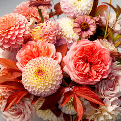 Floral composition of dahlia flowers, roses and autumn leaves. Arty, bright red and pink color  bouquet of flowers 
