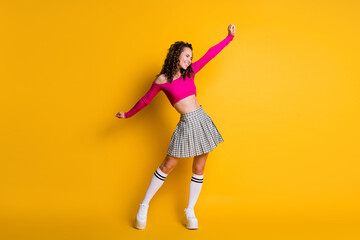 Fototapeta na wymiar Full length photo of attractive charming crazy glad lucky wavy lady raise spread arms wear pink cropped top mini plaid skirt white socks shoes isolated yellow color background