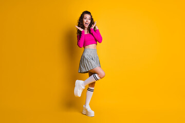 Fototapeta na wymiar Full size photo of nice pretty lovely crazy excited good mood wavy lady wear pink naked shoulders top mini plaid skirt white long socks footwear isolated shine yellow color background