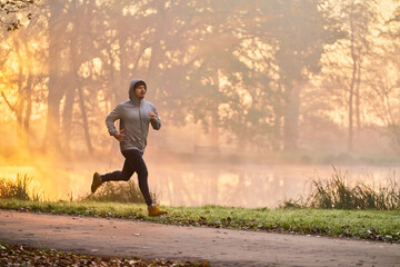 Man jogging in the park during autumn morning