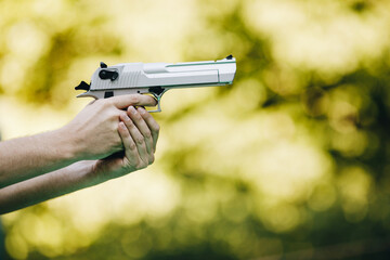 gun in hand against a green background