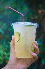 Selective focus honey lemon soda holding in hand natural background