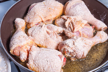 Cooking Tuscan Chicken - Frying pieces of flour-boned chicken in a pan.