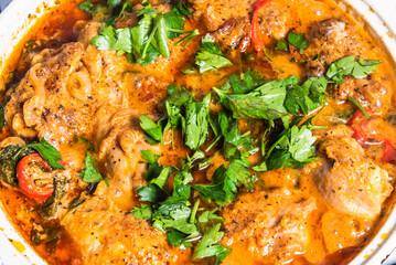 Cooking Tuscan chicken with sun-dried tomatoes, tomato paste, spinach, cream and cheese in a pan.
