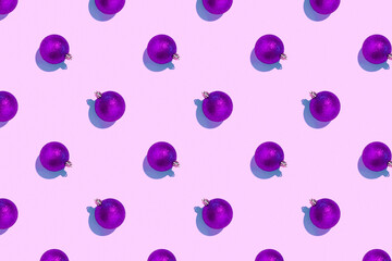 Seamless regular pattern with Christmas balls on a purple background. Hard light. The concept of New Years and Christmas.
