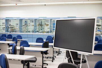 Empty Contemporary multimedia Classroom or conference hall with digital blackboard, chair and desk & screen light.