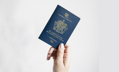 A woman's hand holding a Saint Kitts passport, space for texts