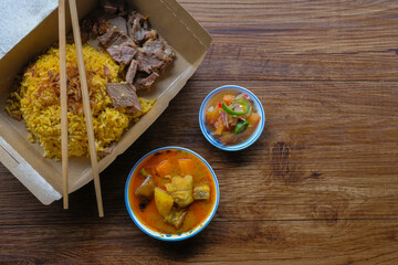 Roasted meat served with rice , dalca and sour sauce . This food is well-known in the Northern Peninsular Malaysia known as 