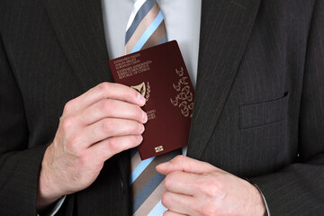 A businessman puts a Cyprus passport in his suit pocket, close-up
