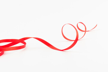 Top view of Red ribbon isolated shiny rolled on white background. Flat lay view.