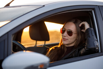 Naklejka premium Young woman driving rented car in the evening