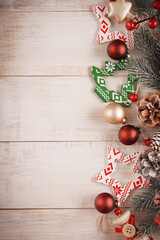 Christmas background with fir branches, pinecones and berries, glass and wooden xmas toys on the...