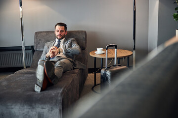 Punctual man managing his time at the departure lounge bed