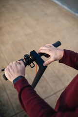 Naklejka premium electric skate with hands touching the buttons. Alternative transport