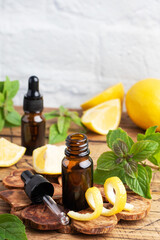 Lemon citrus fruit essential oil and mint, aromatherapy oil natural organic cosmetic on rustic wood background.