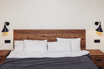 Modern bedroom interior. Bed with wooden headboard