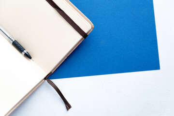 black pen rests on an open notebook