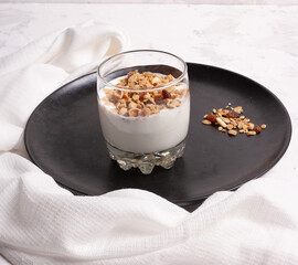 Healthy breakfast. Yogurt with granola, nuts, fruits. On a black background.
