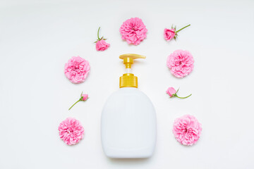 Plastic bottle with dispenser with flowers and rosebuds isolated on a white background top view, flat composition, with space for text, skin care concept, personal care, design, product advertising