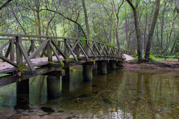 Fototapeta na wymiar Wooden bridge in Vrelo Bosne Park in Sarajevo. Bosnia and Herzegovina
