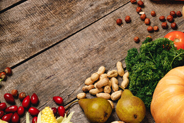 Top view of vegetables, dogwood and nuts on wooden table
