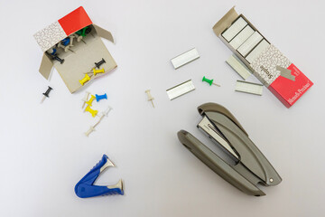 Fototapeta premium Office supplies on a white background. Stapler, staples, pioneers