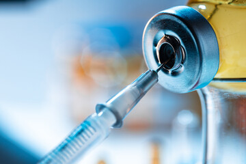 Vaccine bottle with a syringe taking the vaccine from it