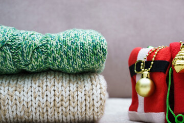 a stack of warm knitted clothes and Christmas decorations