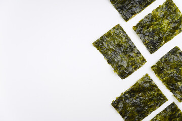 Fototapeta premium Nori chips on white background. Sushi, recipe, menu, seaweed, iodine concept. Top view, flat lay, copy space