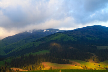 Cloudy morning spring rural landscape in the Carpathian mountains. Dramatic sky before dawn.