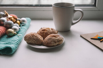 Christmas decorations, a cup of tea and homemade cookies on the windowsill