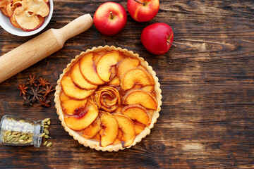 Apple tart pie and red apples on wooden table