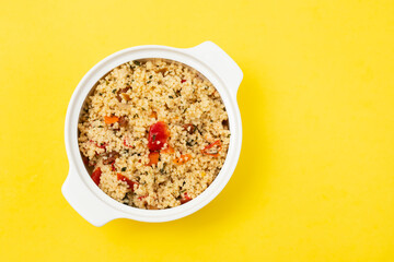 tabbouleh on small white bowl on yellow background