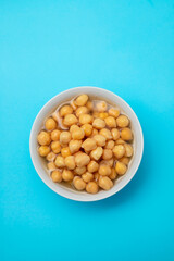 boiled chick pea in white bowl on blue background