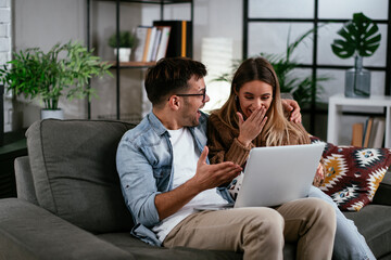 Happy young couple with laptop at home