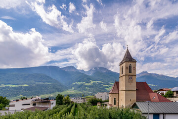 The parish church Pfarrkirche St. Johannes der T&auml;ufer in Corzes, South Tyrol, Italy, against a dramatic sky