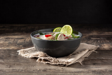 Traditional Thai food Tom Kha Gai in bowl on wooden table
