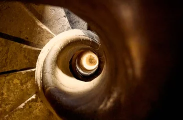 Fotobehang Trappen Closeup shot of spiraling stone stairs  © Érik Glez.