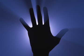 Human hand silhouette in the light of a spotlight.