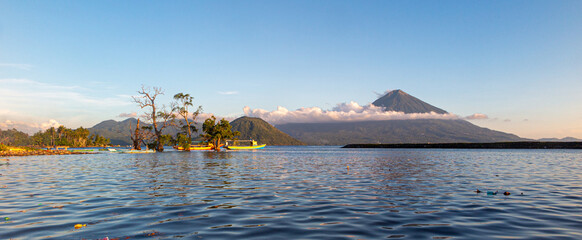 View over the tropical ocean in indonesia with boats and vulcano island in background