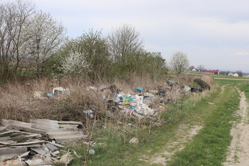Poorly understood caring for the environment - Illegal garbage dump among fields and a small forest