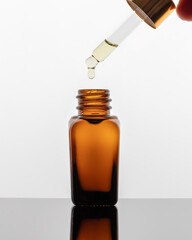 A drop of essential oil falling into a bottle