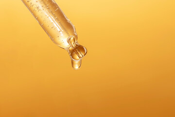 macro of pipette with liquid and drop on gold background