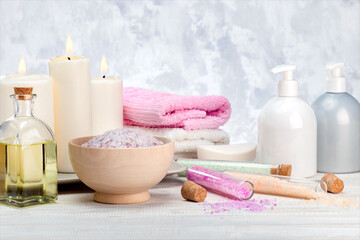 Obraz na płótnie Canvas Spa cosmetics products, lotion, cream, bath salt, essential oil, soap, towels on wooden shelf.