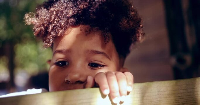 Close-up of african-american little boy hiding face playing peek-a-boo